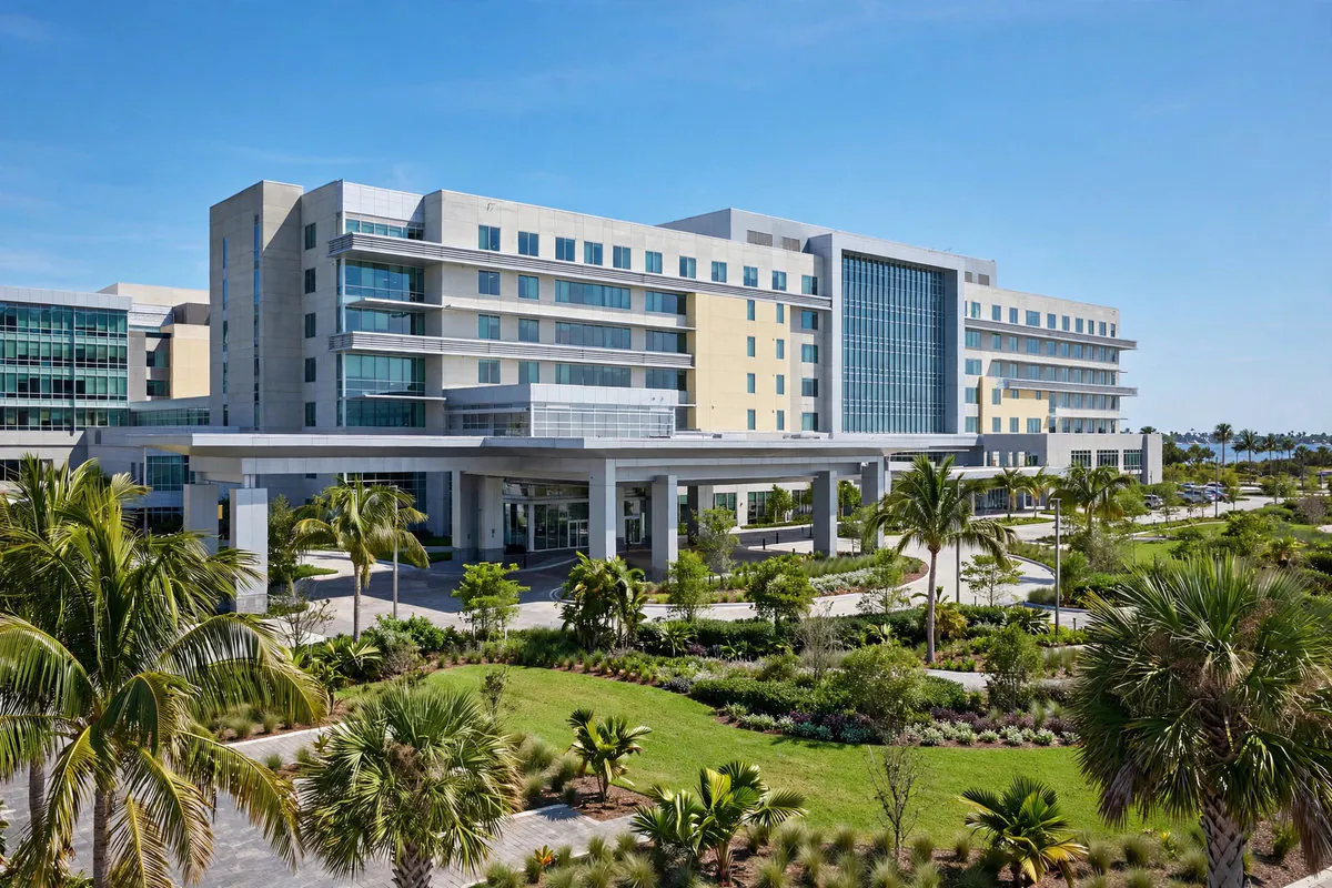 Large modern hospital in Clearwater, Florida, with palm trees, landscaped grounds, and a covered main entrance under a clear blue sky — Rafferty Domnick Cunningham & Yaffa